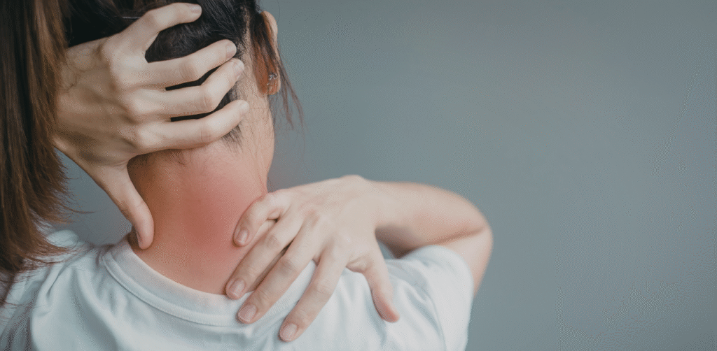 Person holding the back of their neck with both hands, highlighting neck pain or muscle strain with a red area indicating discomfort