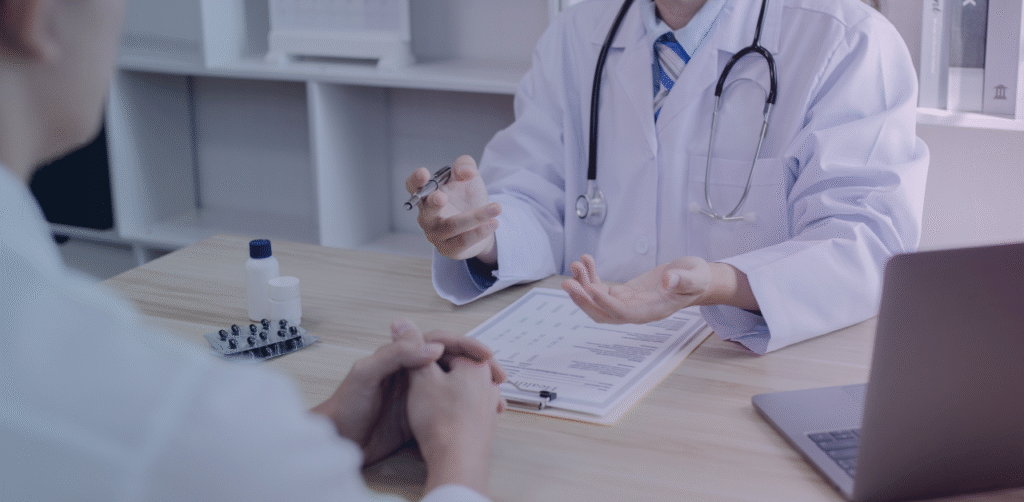 Doctor consults with a patient, discussing medical history and treatment options across a desk