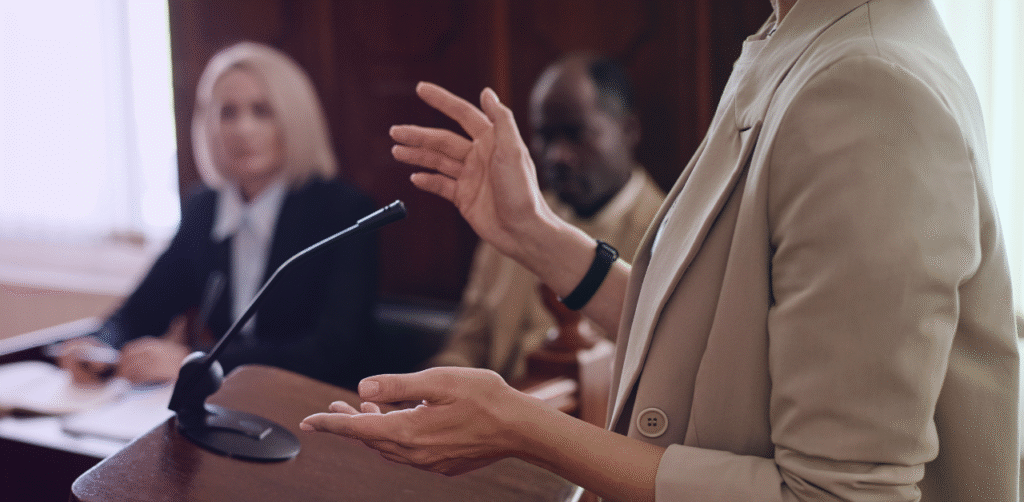 Witness speaks at a courtroom podium while addressing the court