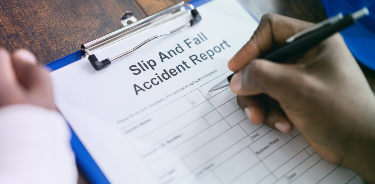 Person fills out a “Slip And Fall Accident Report” form attached to a blue clipboard
