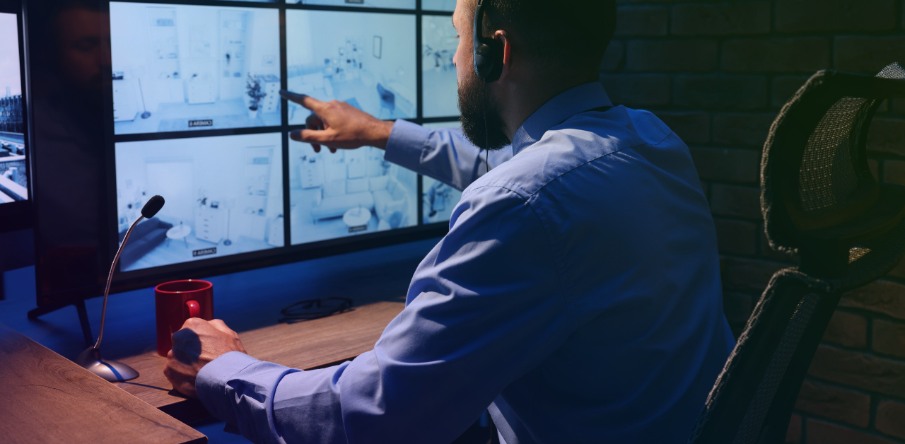 Security operator monitors multiple surveillance camera feeds from a control room